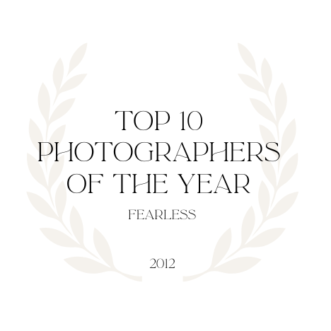 Minimalist text design showing 'Top 10 Photographers of the Year' with decorative laurel wreath elements.