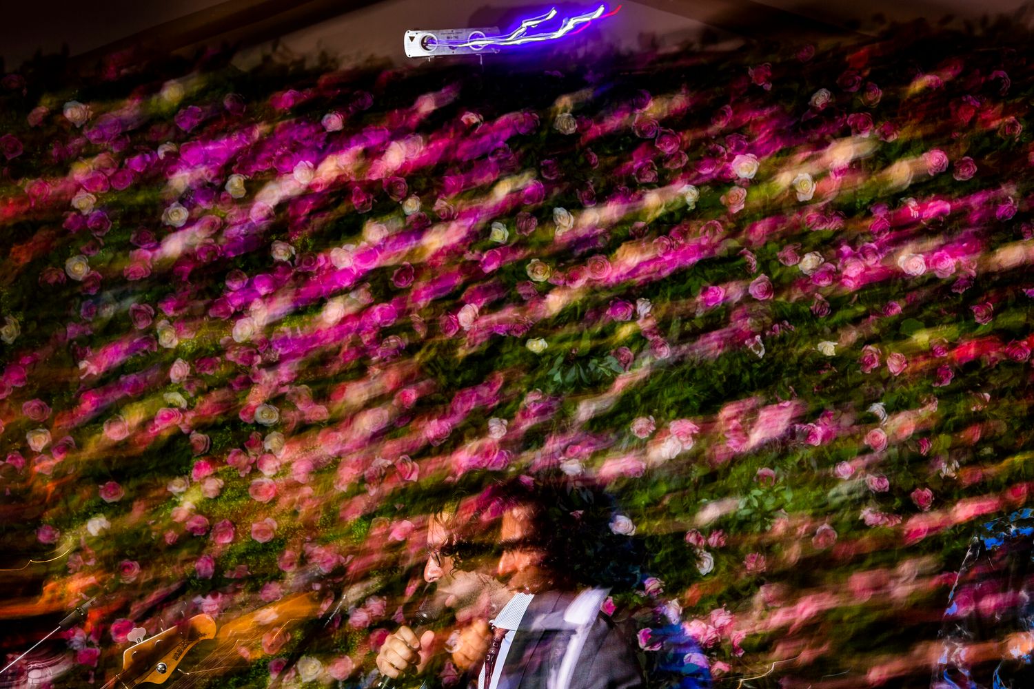Abstract light painting with streaks of pink, green and orange colors creating a dynamic motion blur effect.