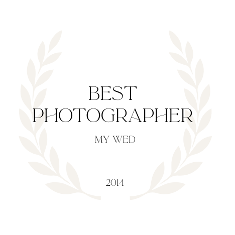 Elegant wedding photography award badge with laurel wreath design in cream and gray colors.