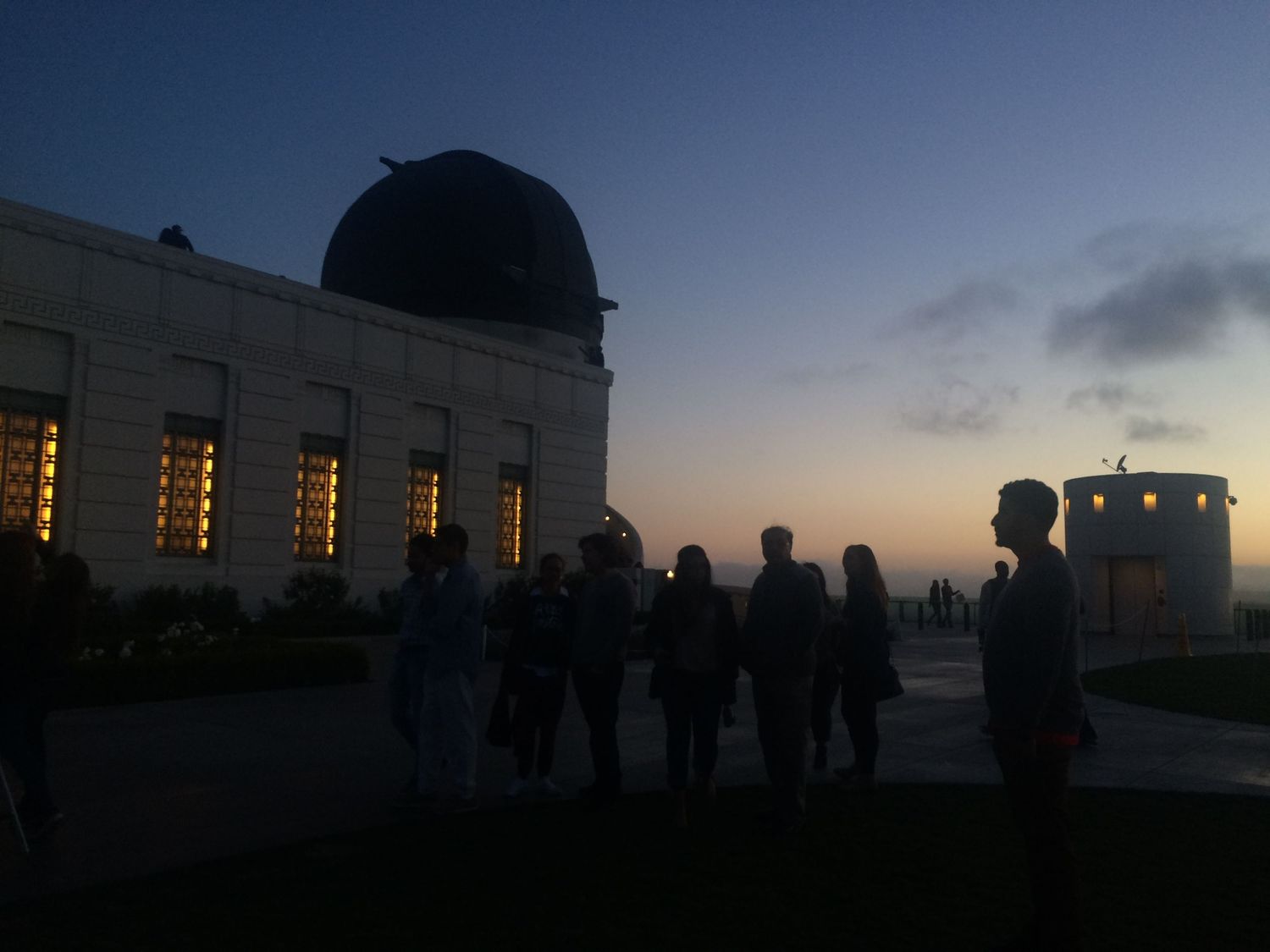 Visitors gather at the iconic Griffith Observatory during a stunning twilight sunset in Los Angeles.
