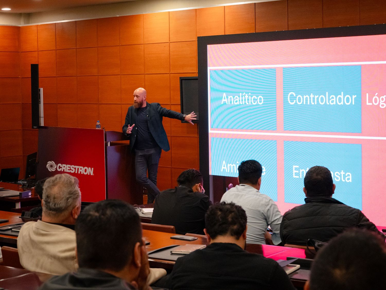 Speaker presenting personality types slide at a Crestron business conference seminar.