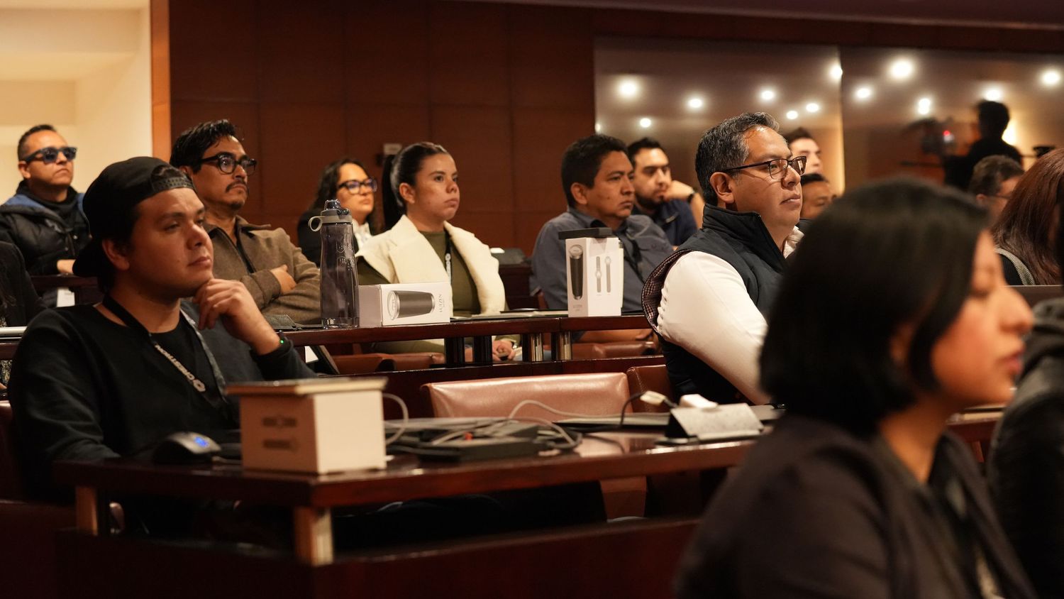 Diverse group of professionals attentively listening during a formal conference or seminar session.