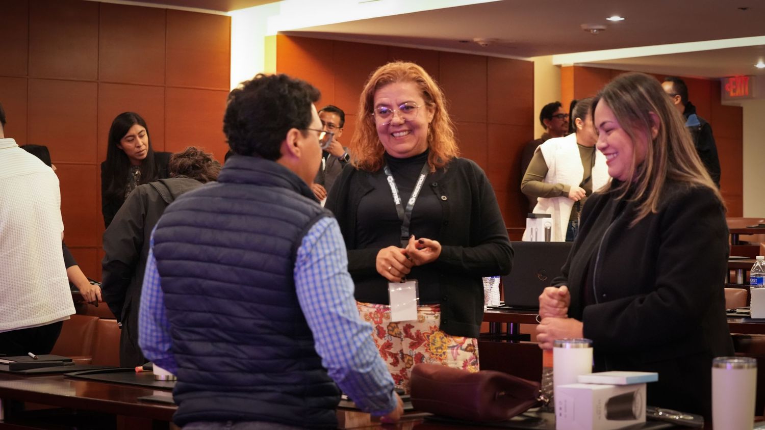 Attendees networking and smiling at a professional business conference event.