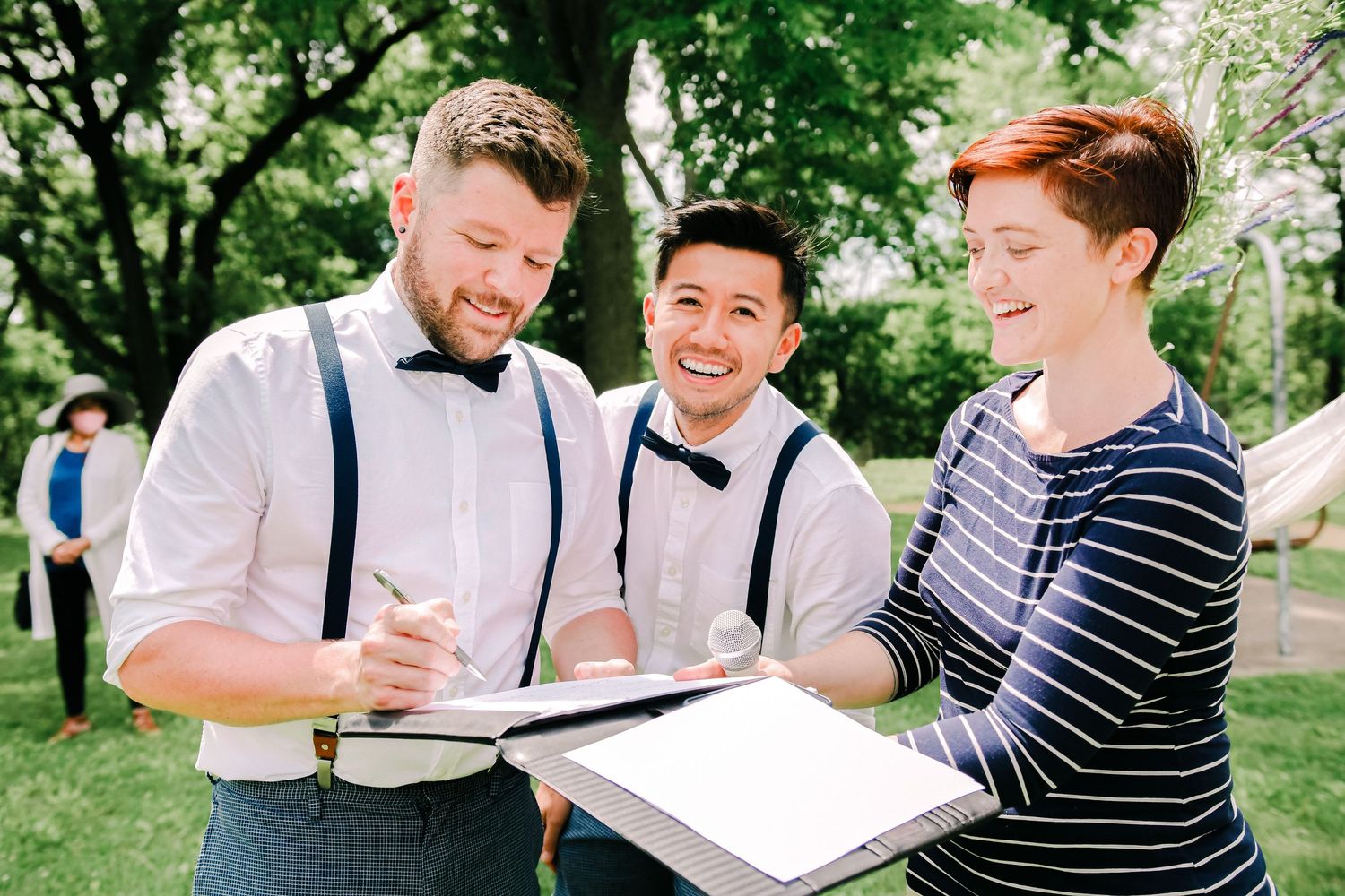 Candid emotional moment between two newlywed grooms at an intimate Twin Cities wedding ceremony by Isabel Sin Photography.