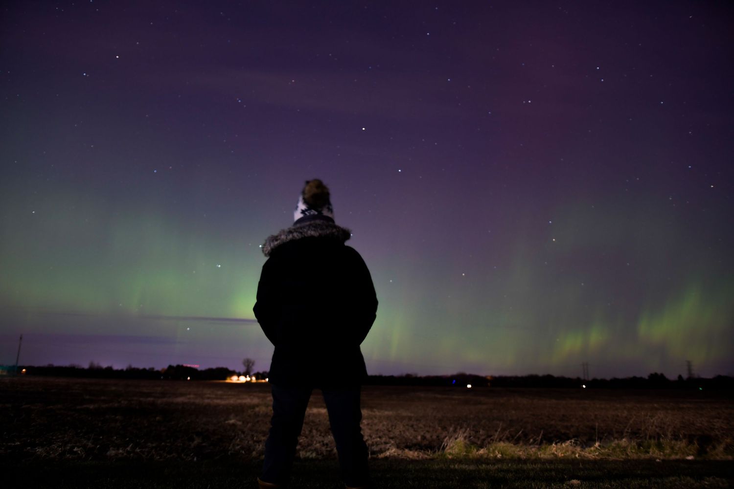 Modern lifestyle portrait of a women with aurora northern lights in the background in Minnesota.