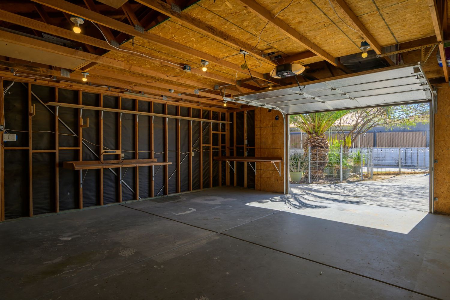 Interior construction view of an unfinished commercial space with exposed wooden beams and concrete flooring.