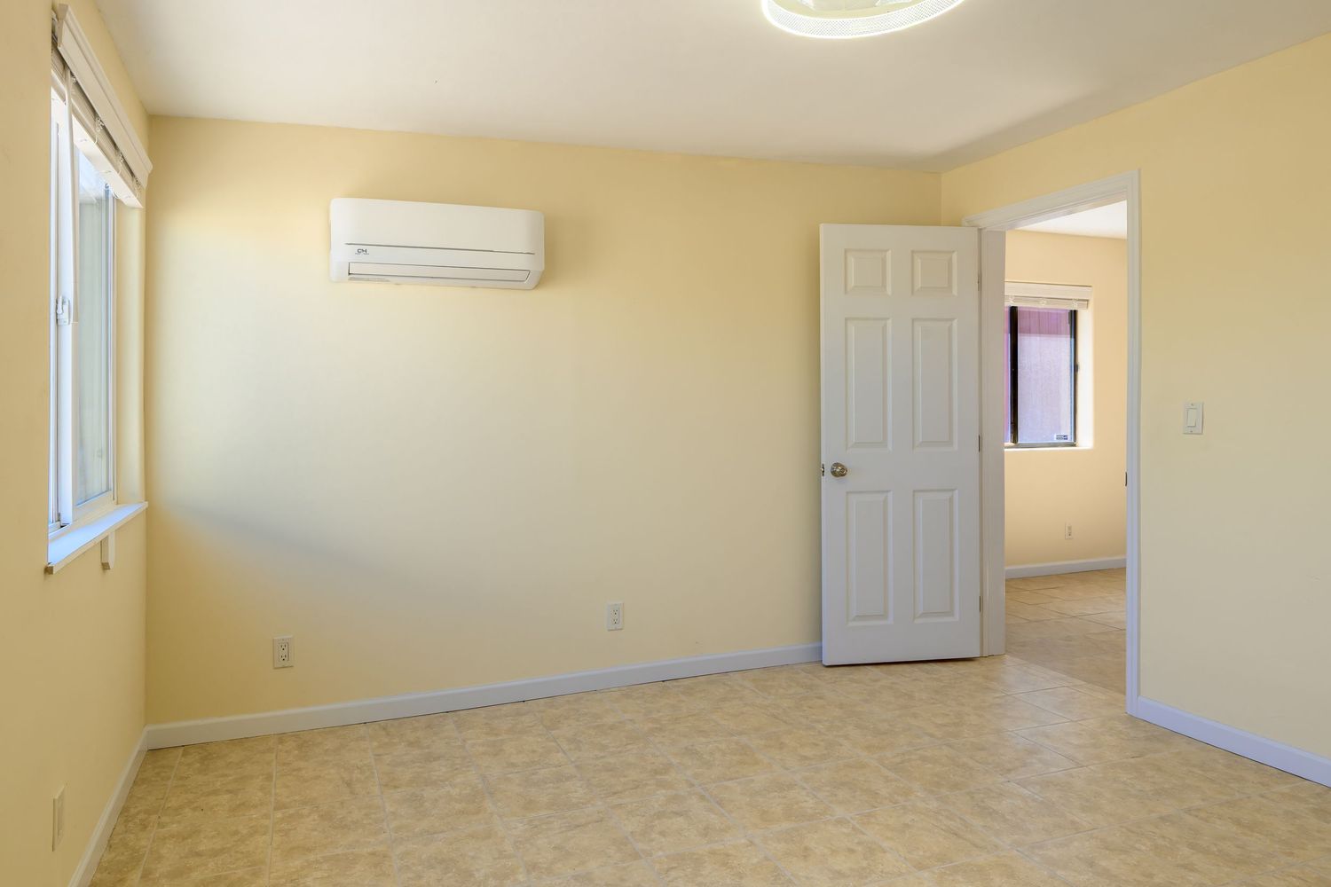Empty room with beige walls, white doors, and carpet flooring shown in a panoramic view.