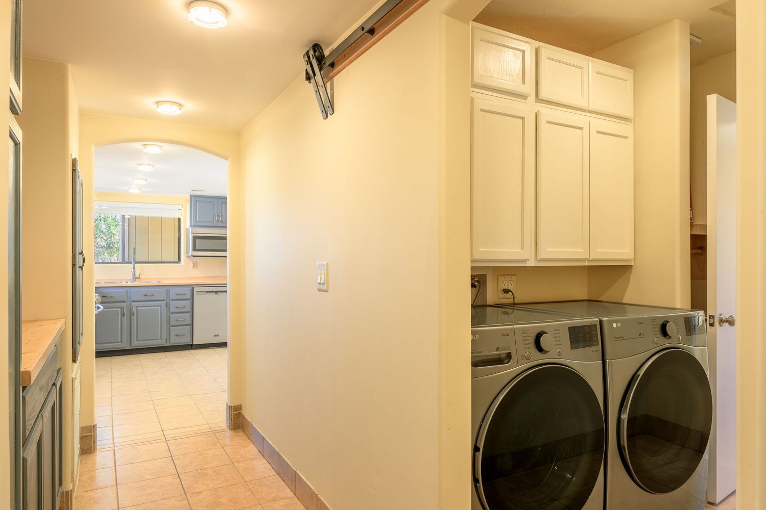 A bright white laundry room with stacked washer and dryer units mounted on the wall.