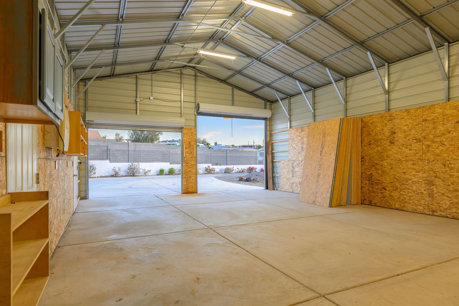 Large empty industrial warehouse interior with wooden beams and concrete floor showing available storage space.