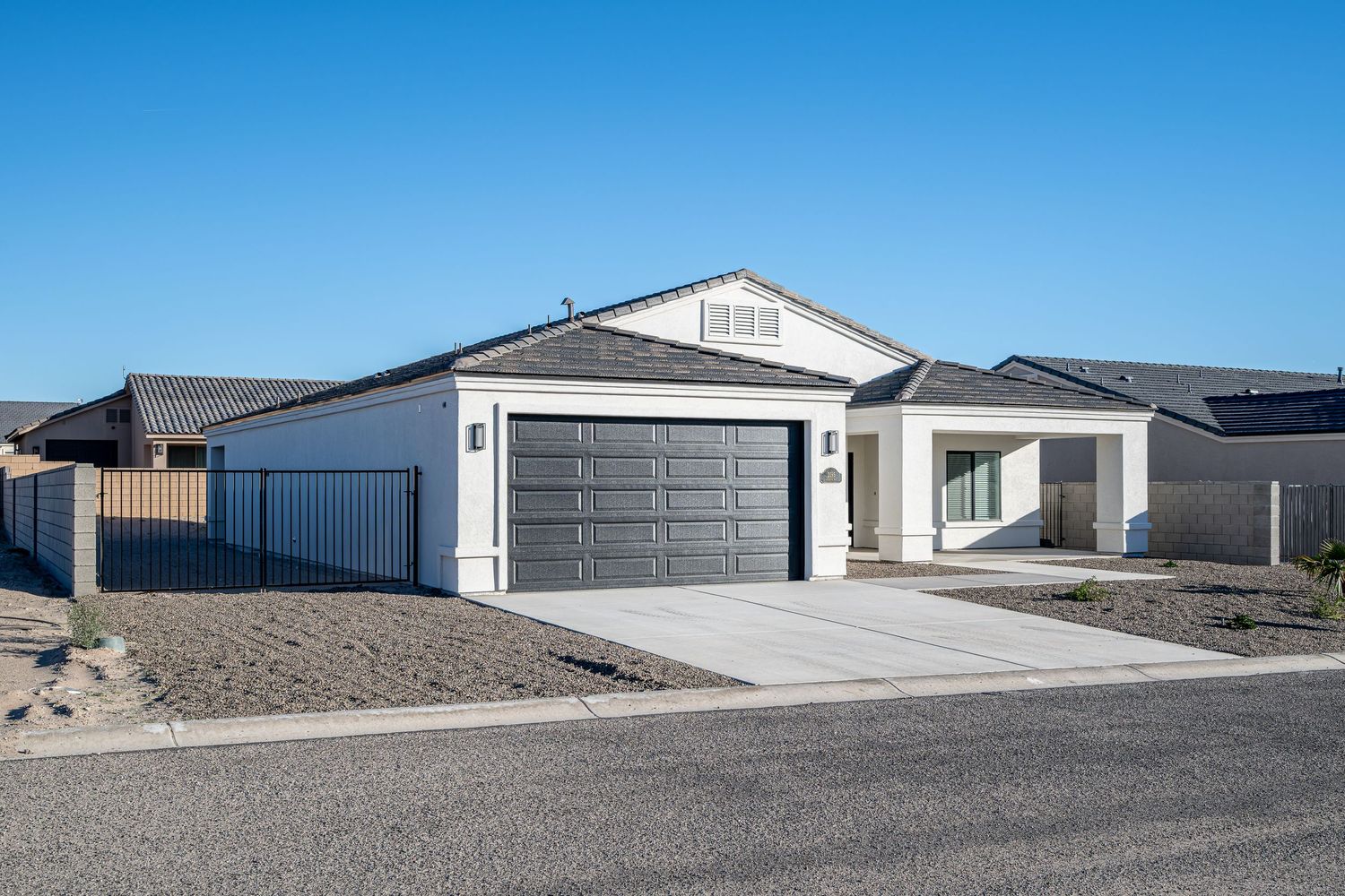 A series of white residential garages and storage units against a bright blue desert sky.