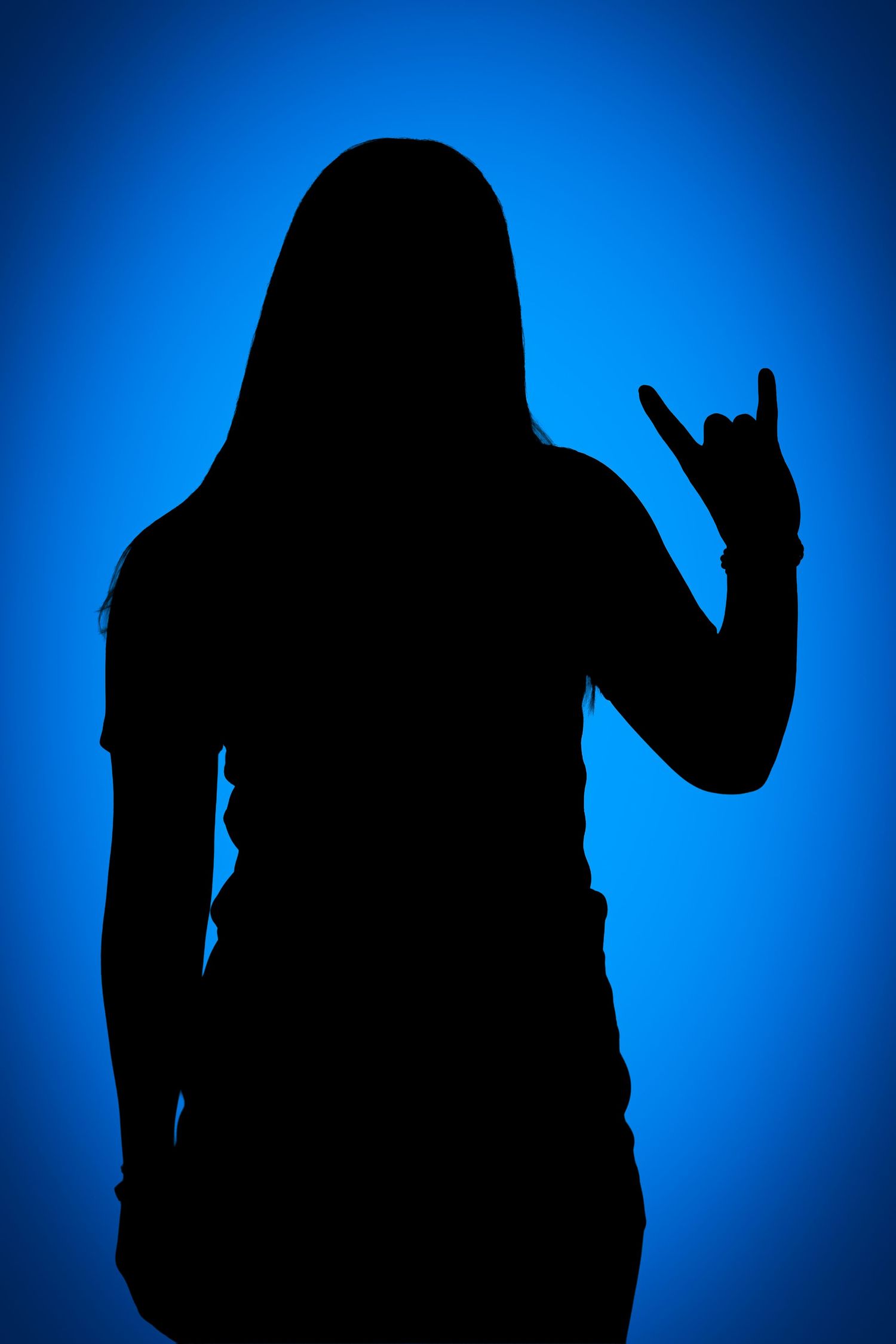 Silhouette of a long-haired person making a rock-on hand gesture against a glowing blue gradient background.