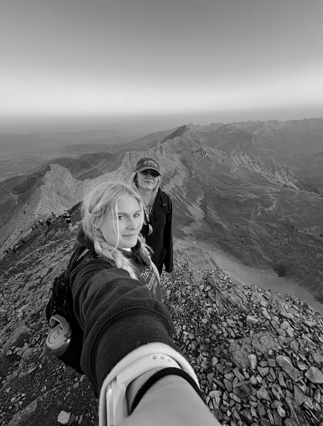 Series of dramatic black and white selfies taken on a rocky mountain peak.