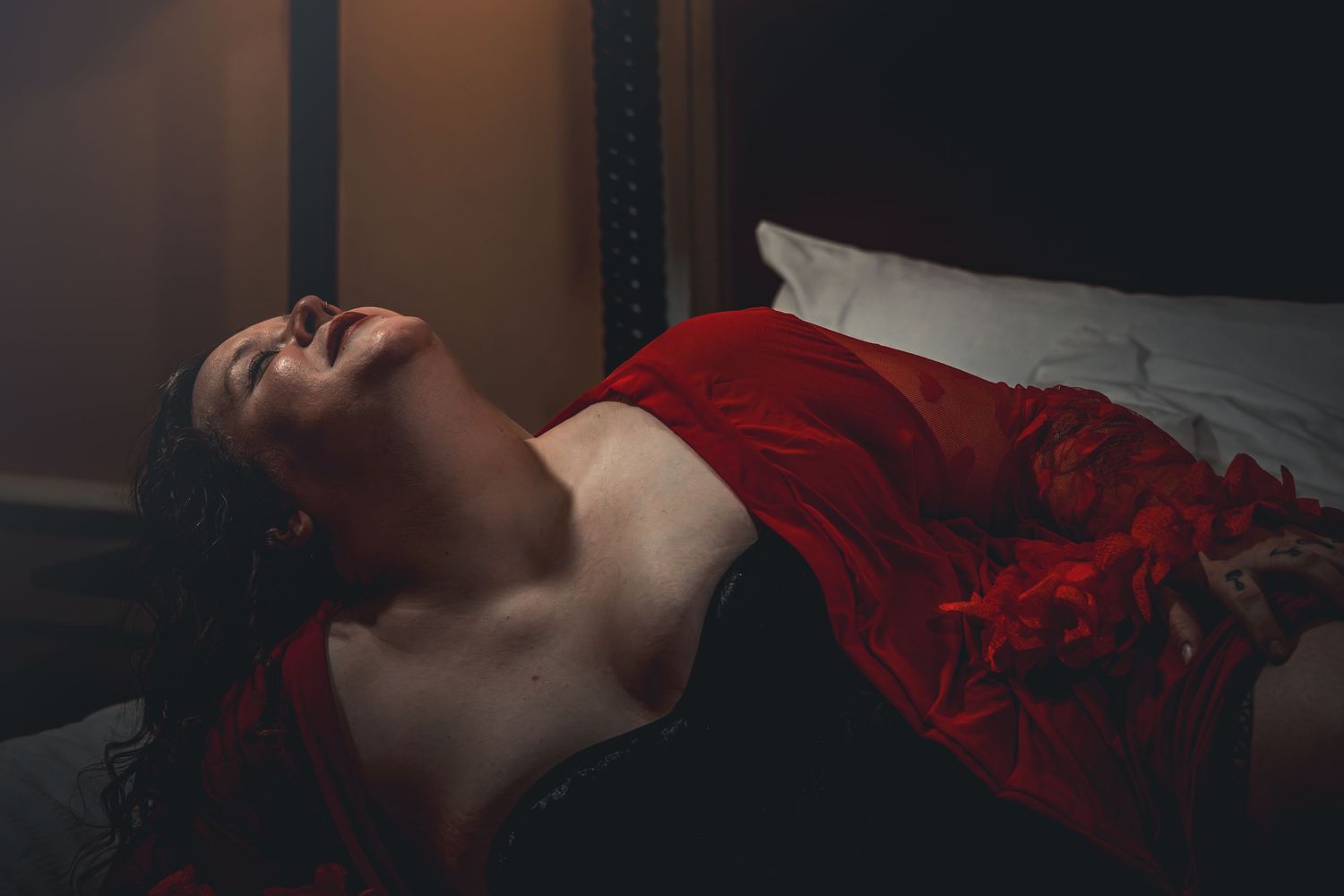 A sequence of six dark moody photographs showing someone lying down in red clothing against a black background.