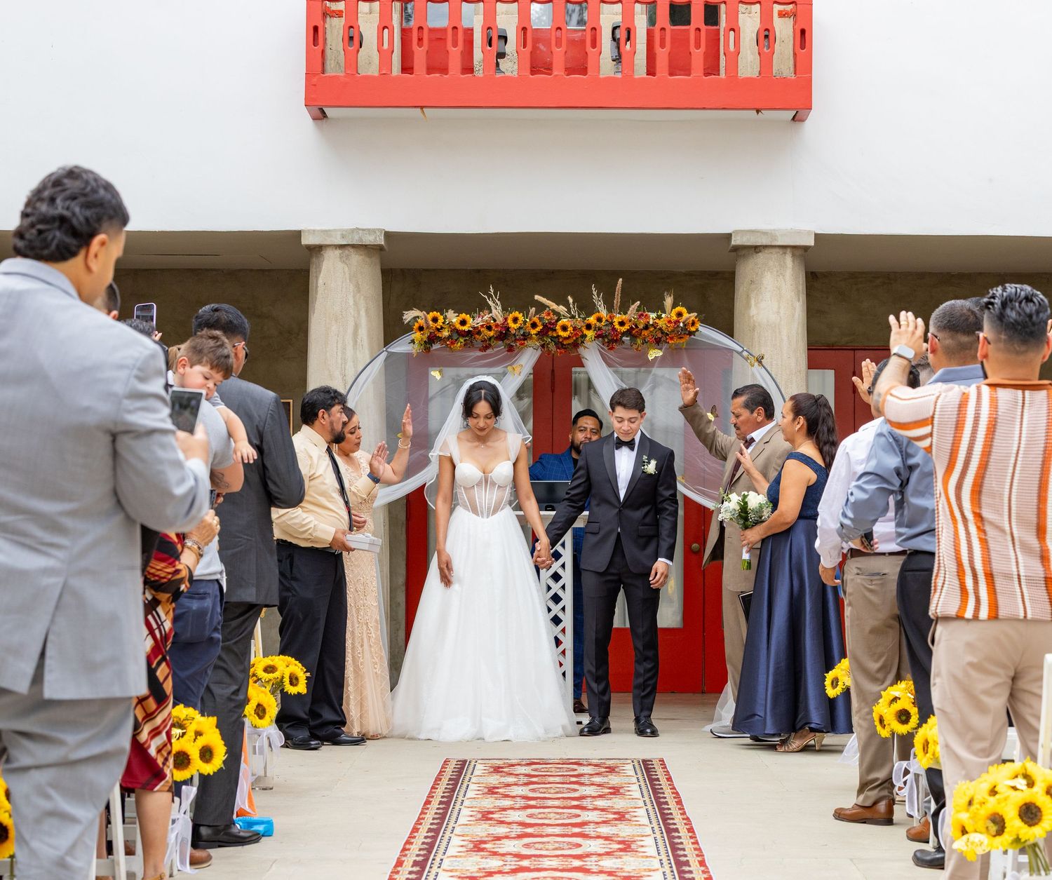 Wedding ceremony setup with red decorative elements and sunflower accents.