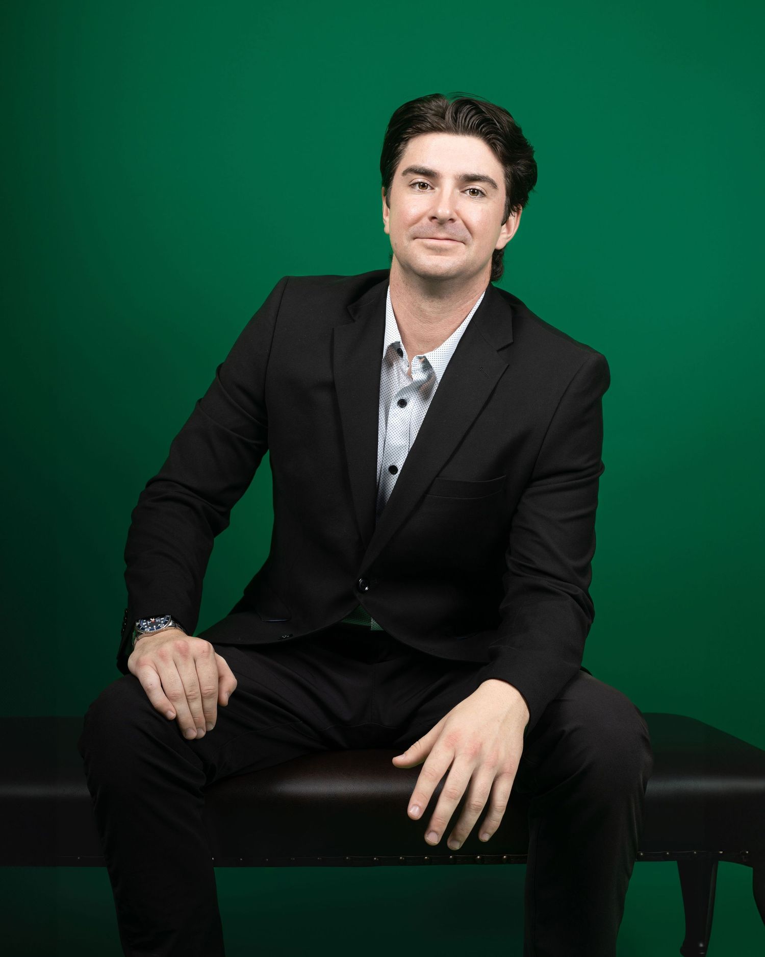 Professional headshots against green backdrop showing different seated poses in formal attire.