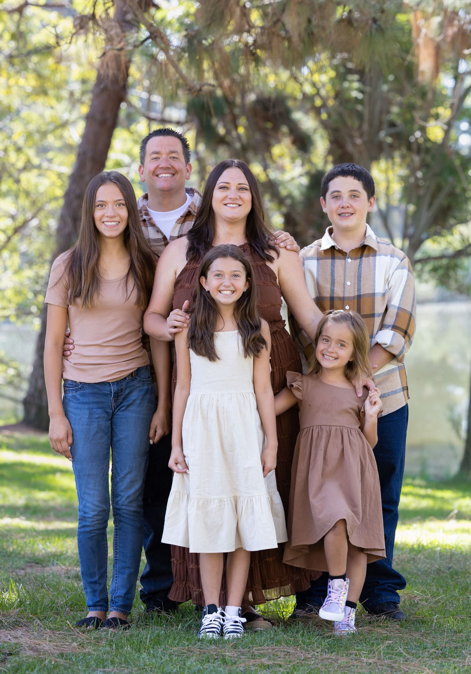 A series of cropped family portraits showing coordinated brown and neutral outfits in an outdoor garden setting.