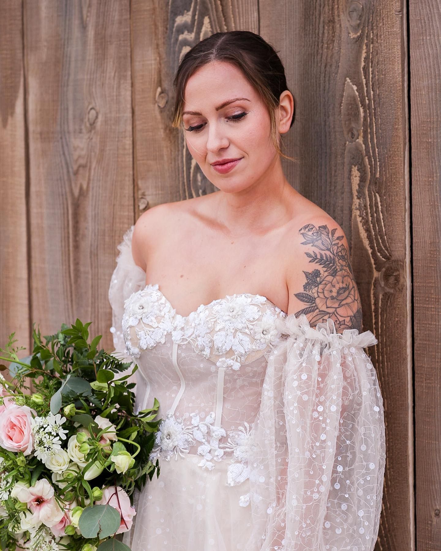 Close-up details of an off-shoulder lace wedding dress with delicate floral appliques.