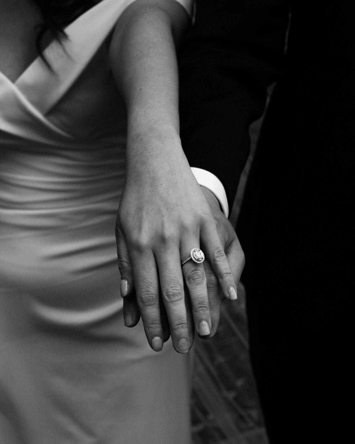 Black and white detail shot of engagement ring on hand.