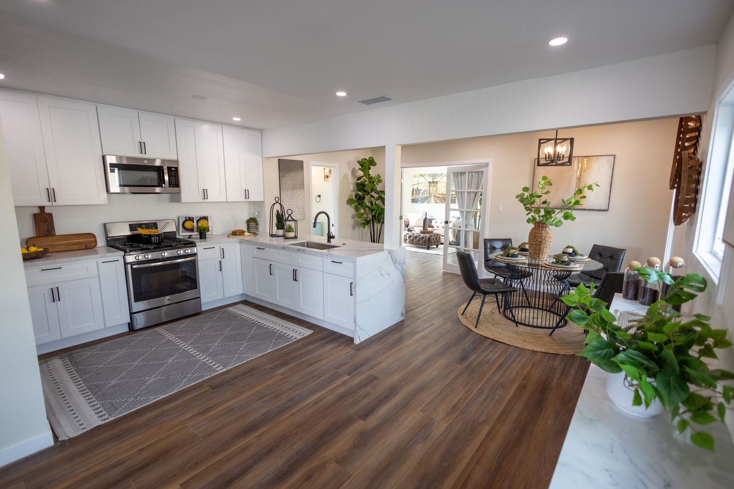 Modern open concept apartment interior with white walls, hardwood floors, and recessed lighting showcases minimalist design.