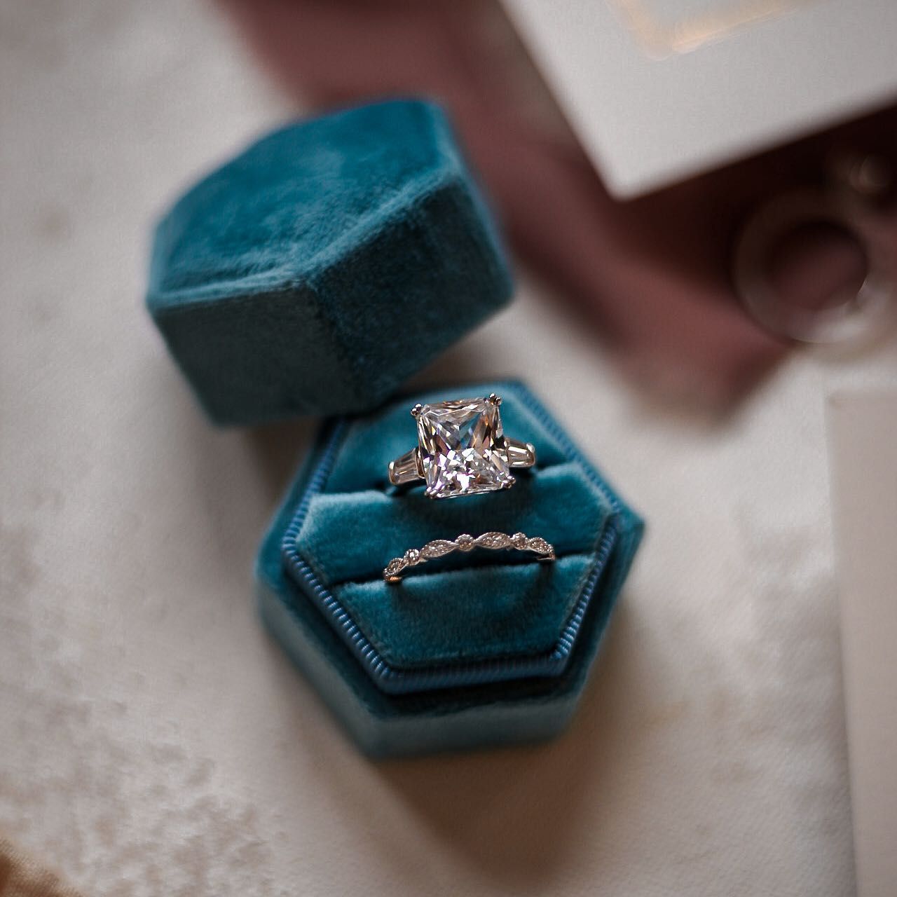 Elegant engagement ring in teal velvet hexagonal ring box.