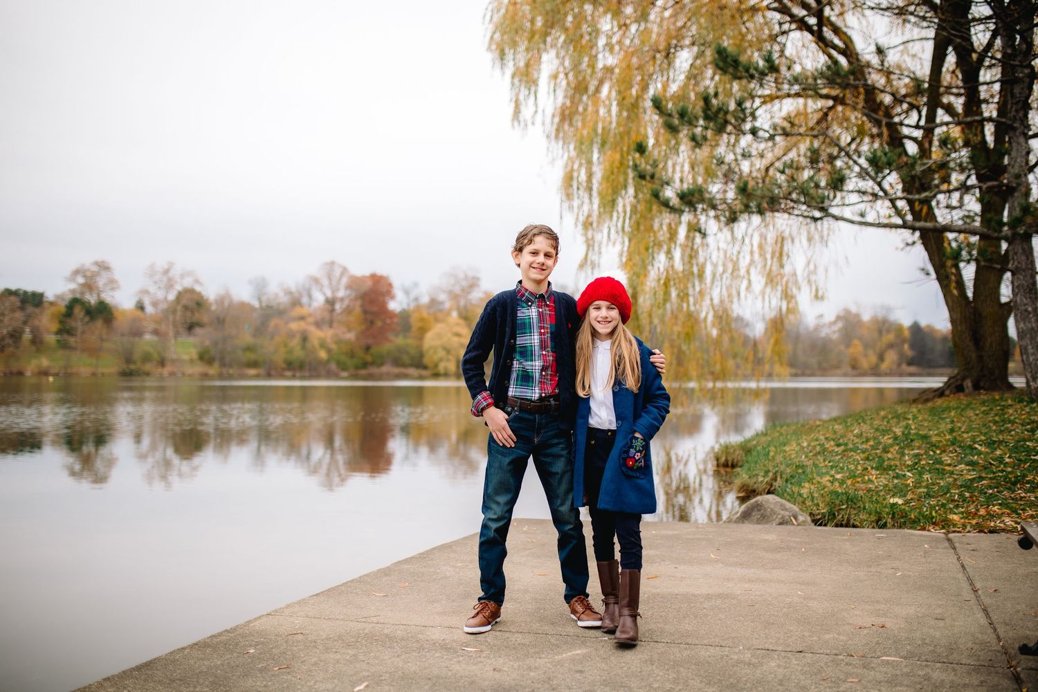 Brother and sister pose at Delaware Park at Hoyt Lake in Buffalo during their family portrait session.