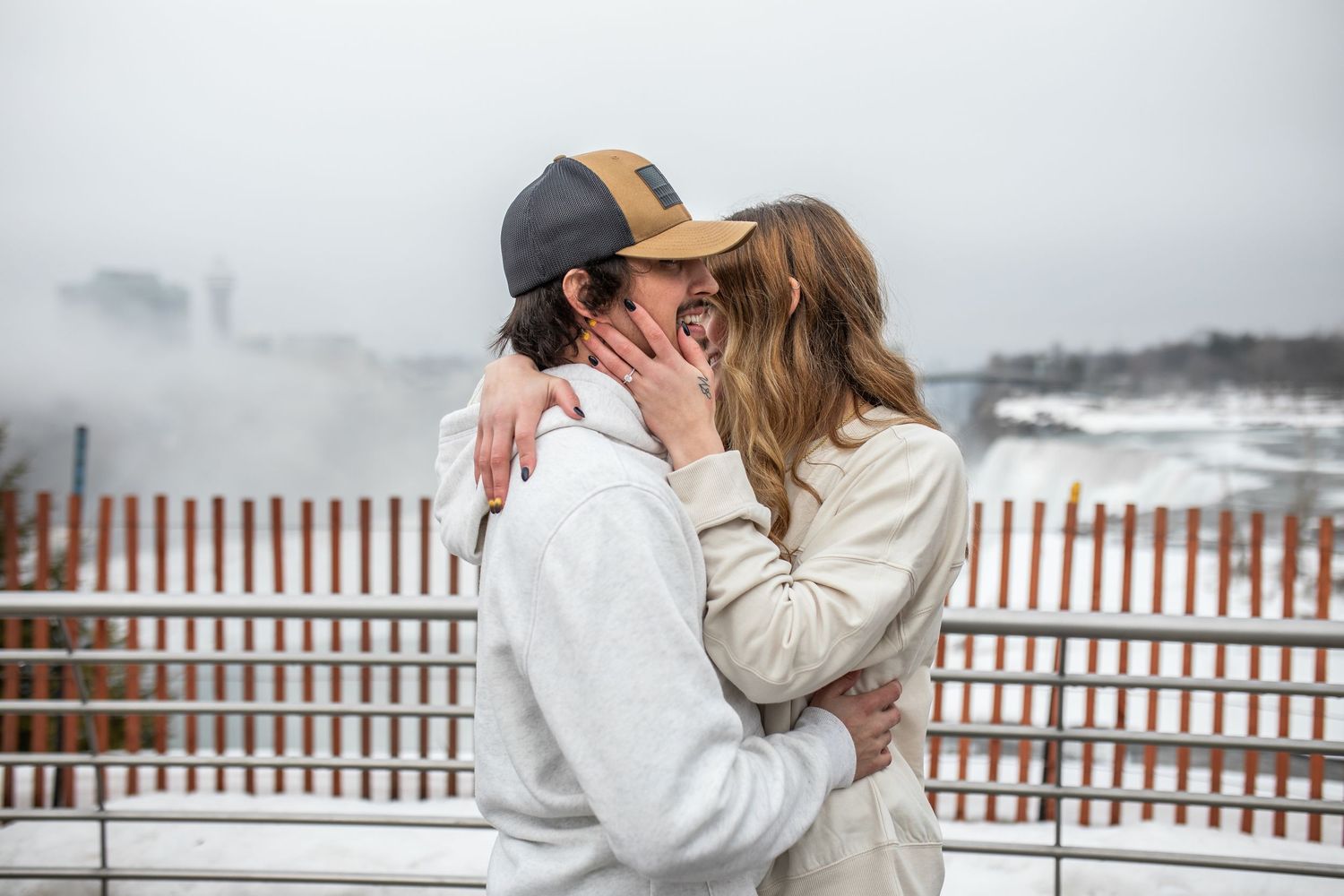 Hunter and Elyse embrace in front of Niagara Falls, New York after Hunter proposed during their engagement session.