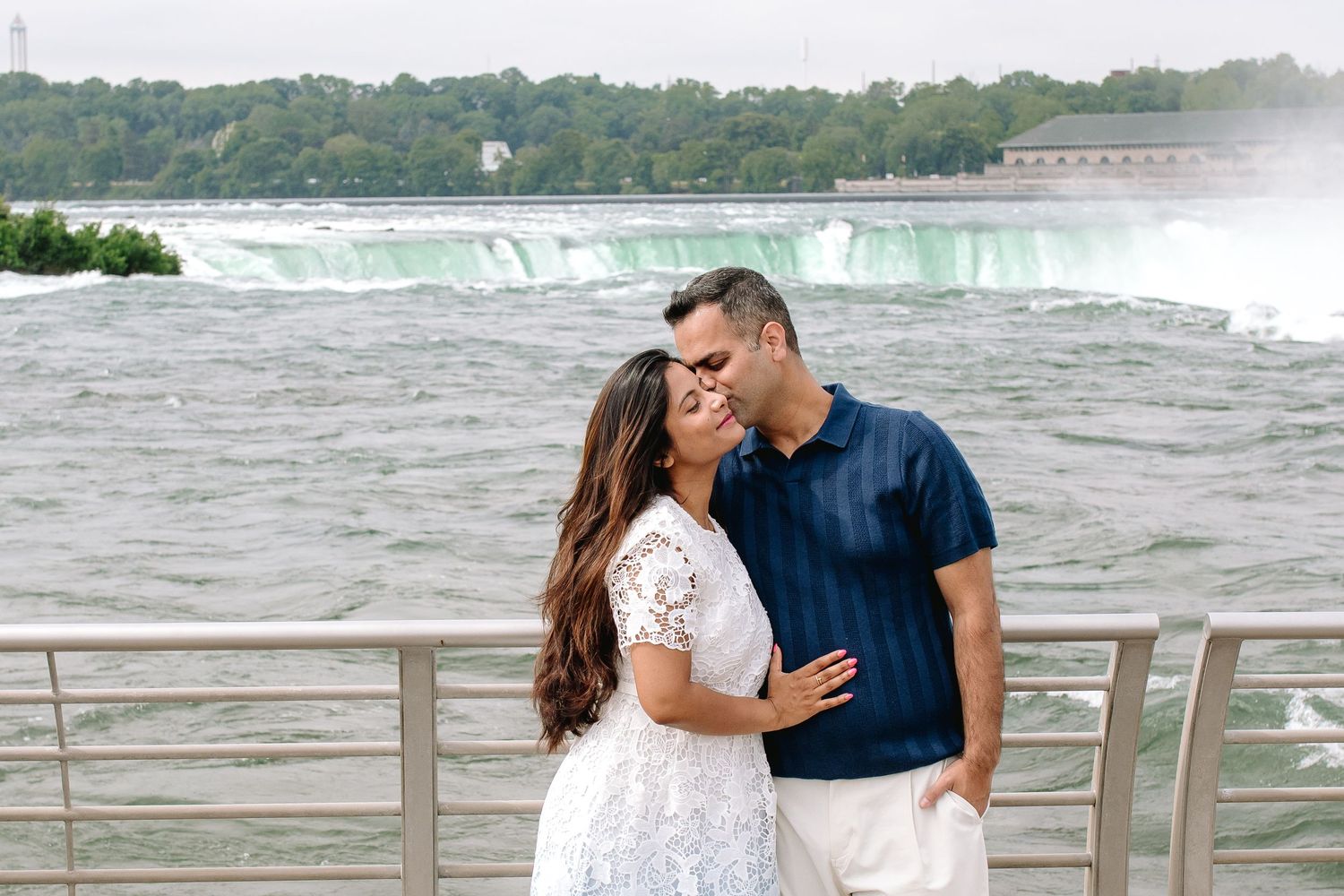 Mom and Dad embrace in front of the rapids in Niagara Falls, New York during their family portrait session.