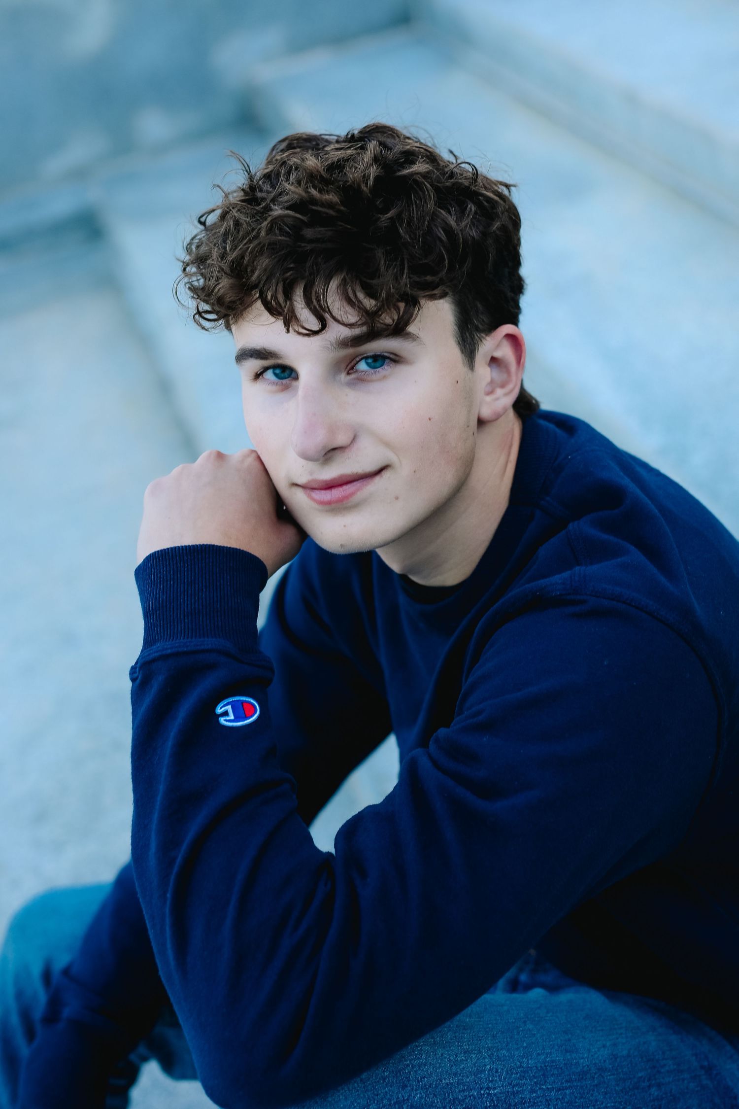 High School Senior Stephen poses on steps during his senior session at hoyt lake in Delaware Park in Buffalo, New York.