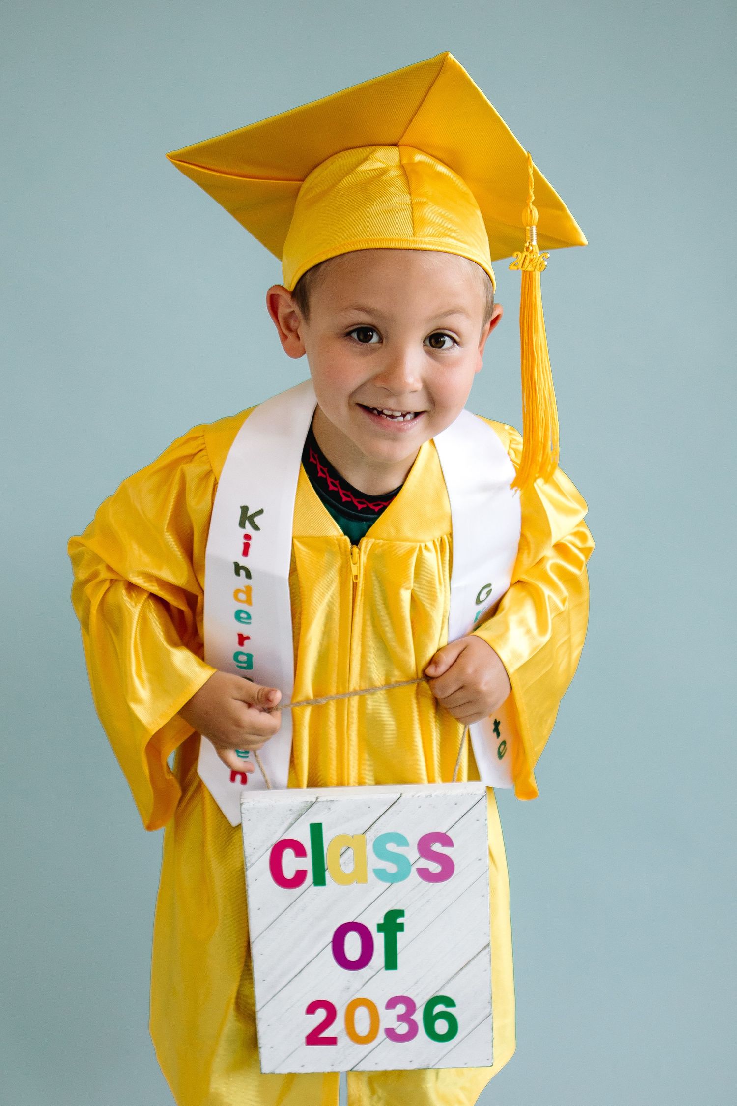 Kindergarten graduate poses on backdrop in studio at The Workspace at The Wurlitzer, Jess Trankle Images studio in North Tonawanda, New York