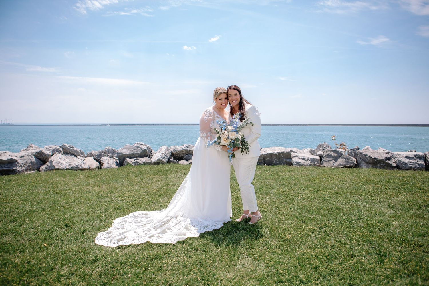 Newly weds and lgbtq couple pose at The Outer Harbor at Wilkeson Pointe in Buffalo, New York after wedding during bridal party portraits.