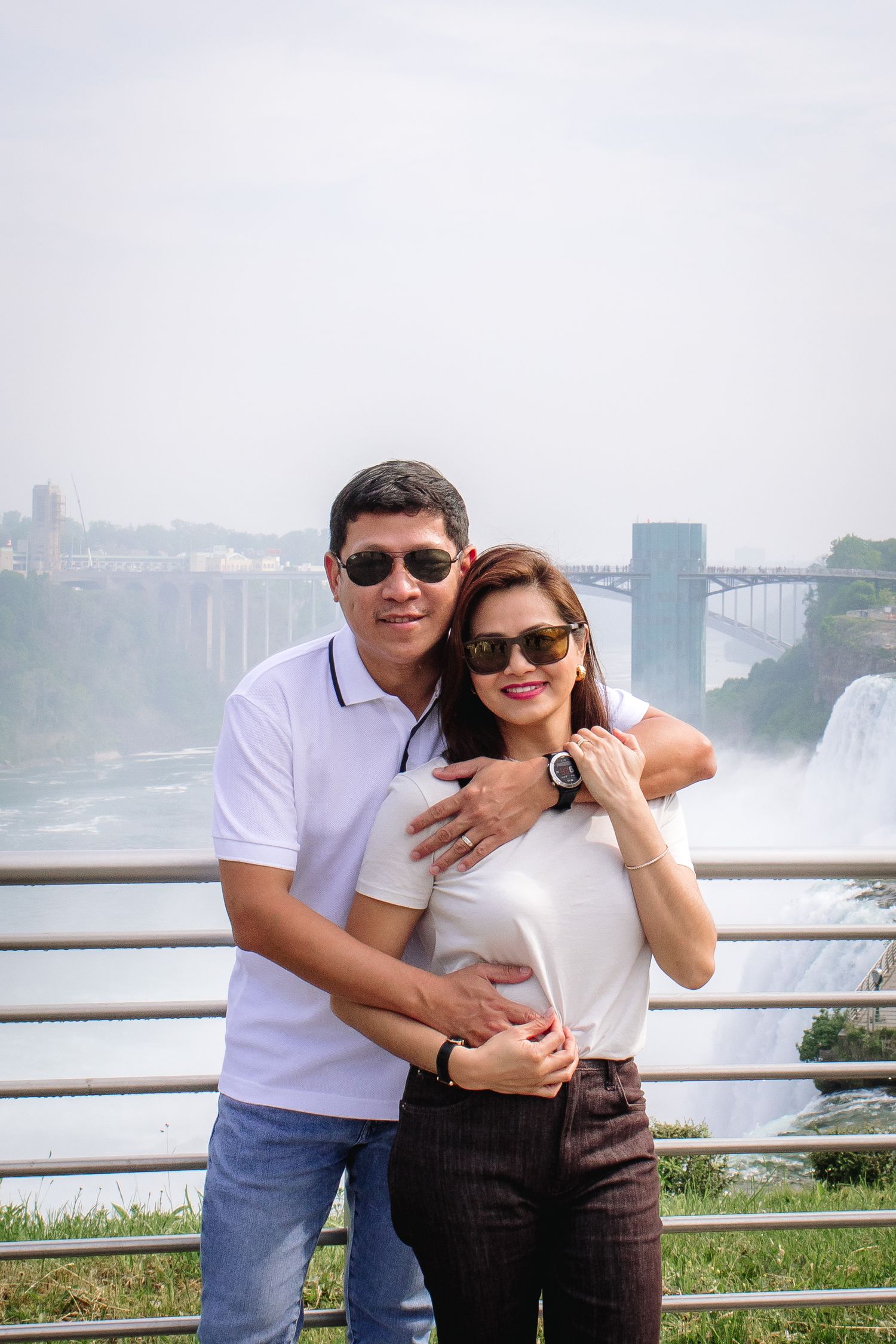 Mom and Dad embrace in front of the rapids in Niagara Falls, New York during their family portrait session.