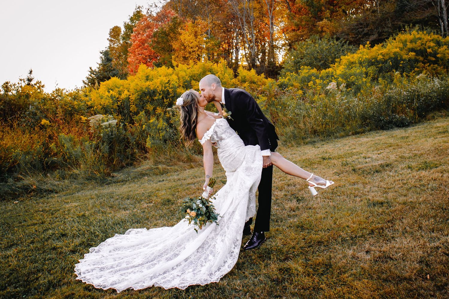 Bride and Groom share a dip kiss in front of the beautiful fall foliage in Ellicottville after their intimate elopement ceremony.