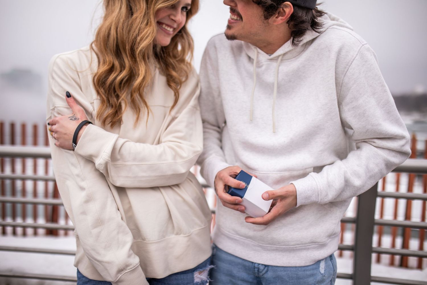 Newly engaged couple displays their engagement ring in front of Niagara Falls, New York after Hunter proposed during their engagement sessio