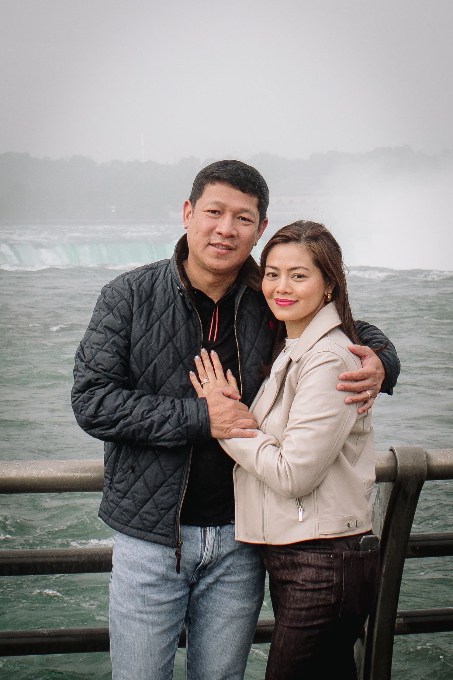 Mom and Dad embrace in front of the rapids in Niagara Falls, New York during their family portrait session.