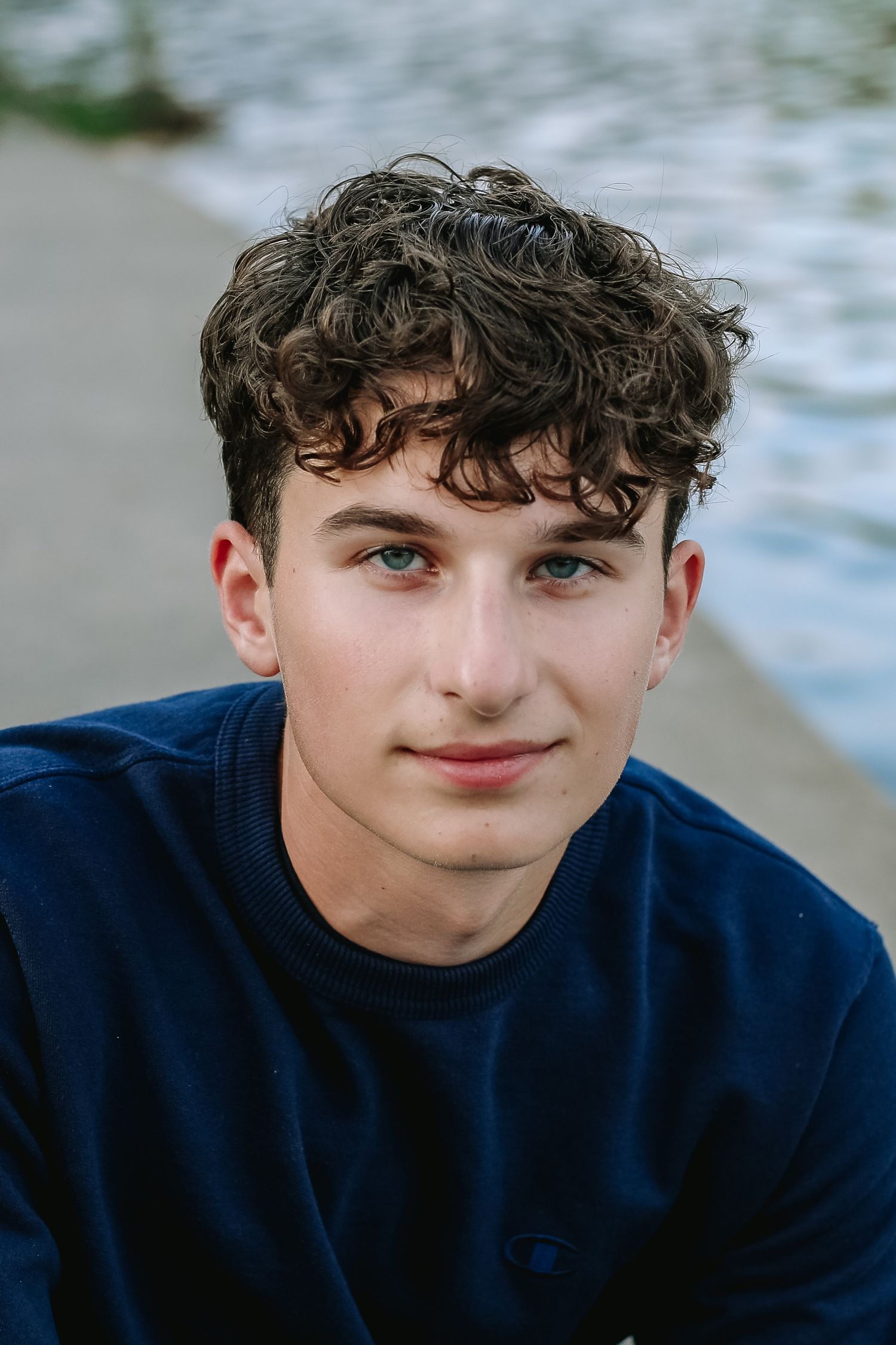 High School Senior Stephen poses under a willow tree during his senior session at hoyt lake in Delaware Park in Buffalo, New York.