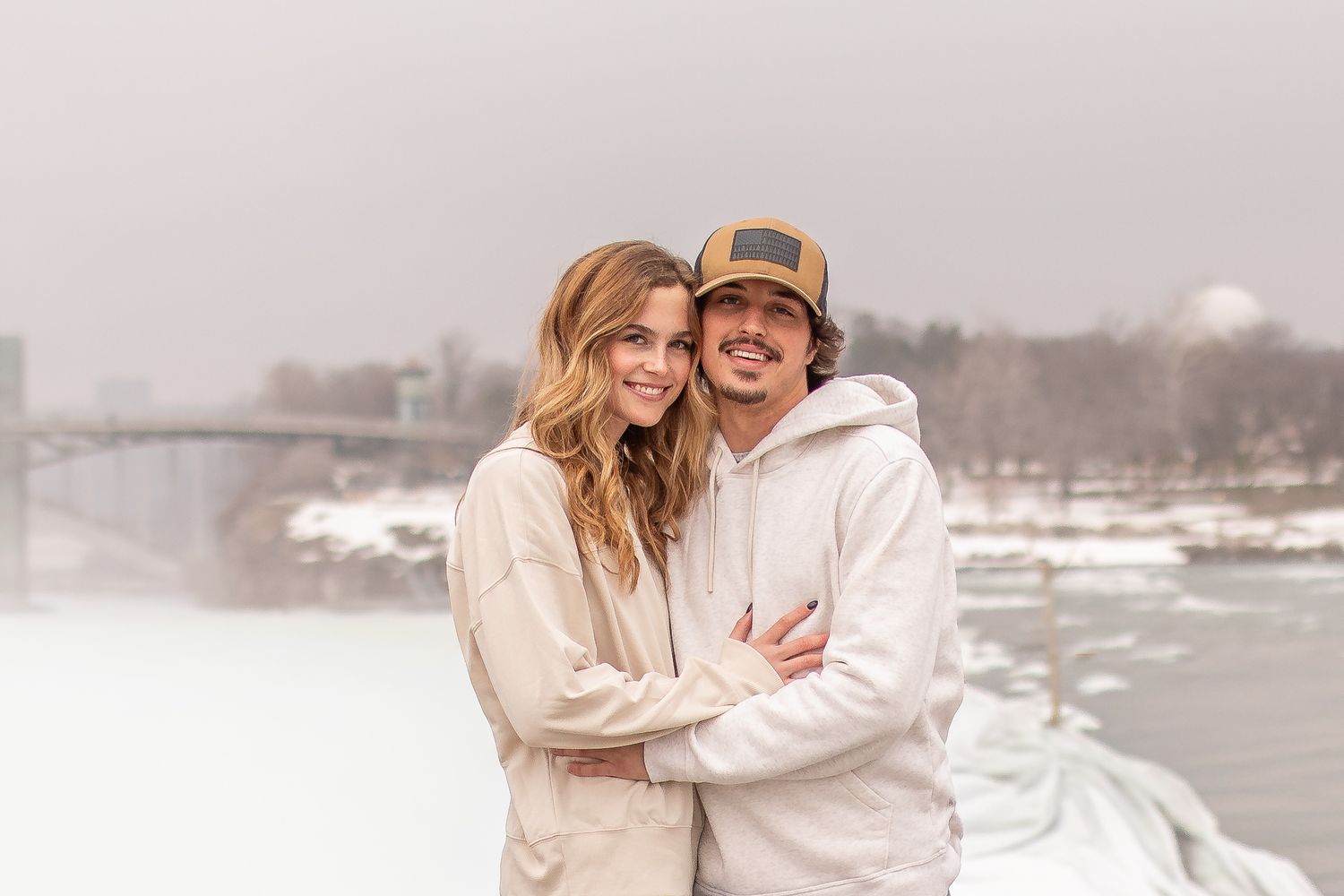 Newly engaged couple look at each other lovingly in front of Niagara Falls, New York after the surprise proposal during their engagement