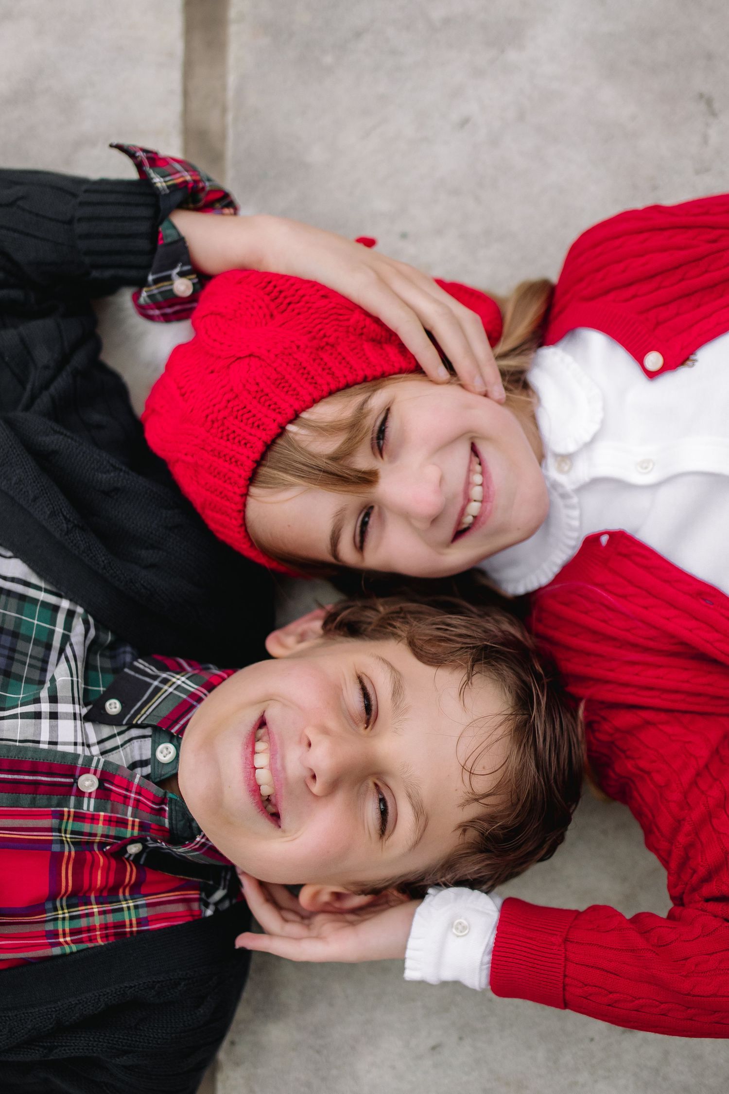 Brother and sister pose head to head at Delaware Park in Buffalo during their family portrait session.