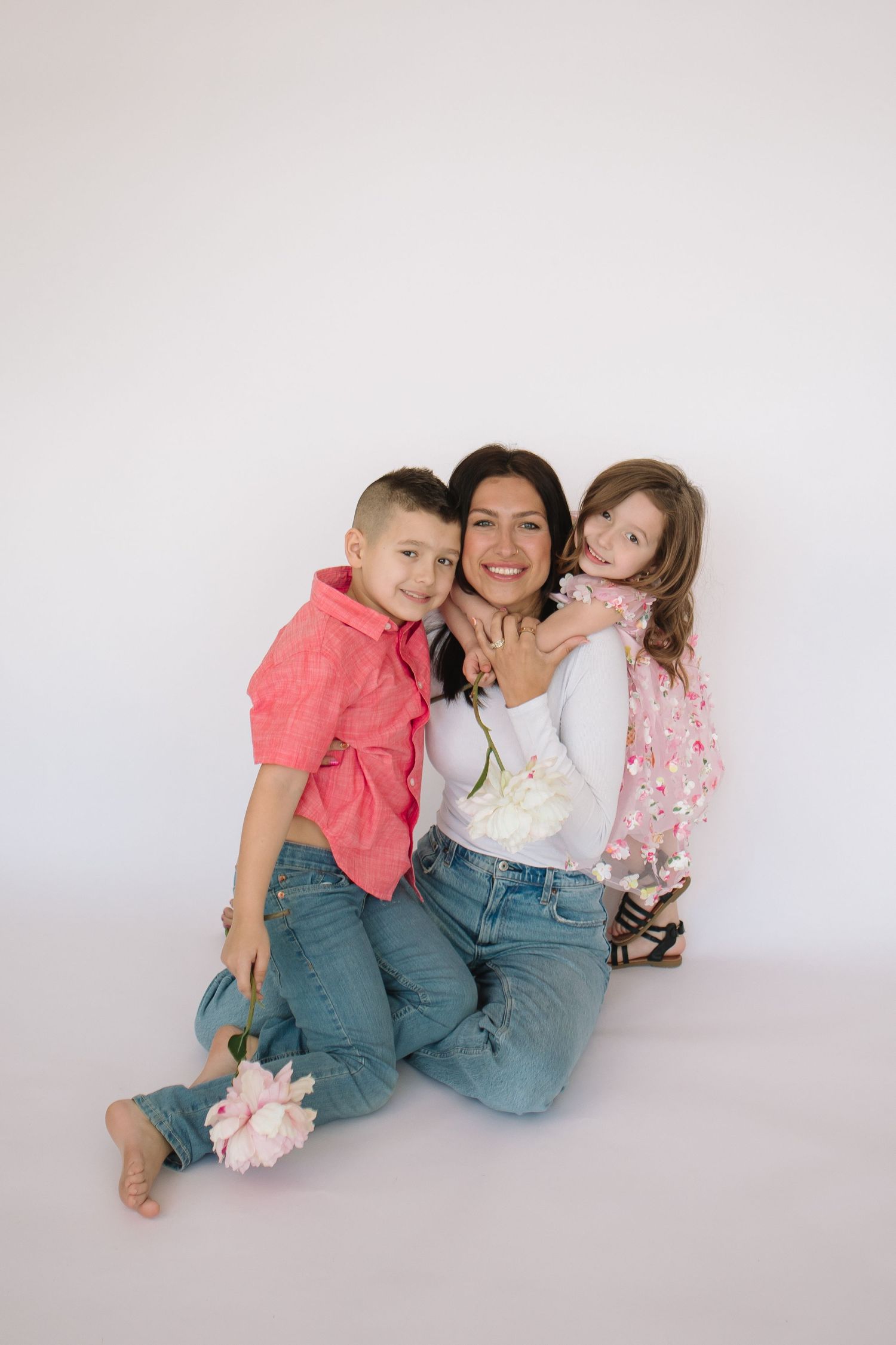 mom and children pose together on a white backdrop at their mother's day photo session at the Wurlitzer in North Tonawanda, New York.
