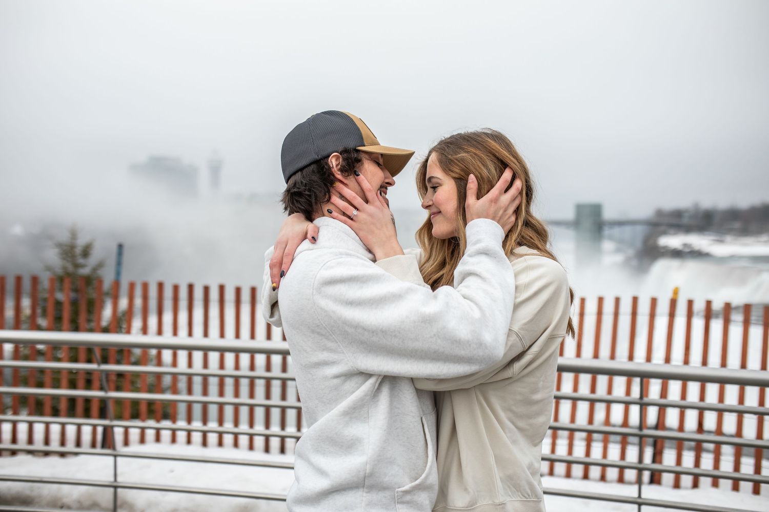 Hunter and Elyse embrace in front of Niagara Falls, New York after Hunter proposed.