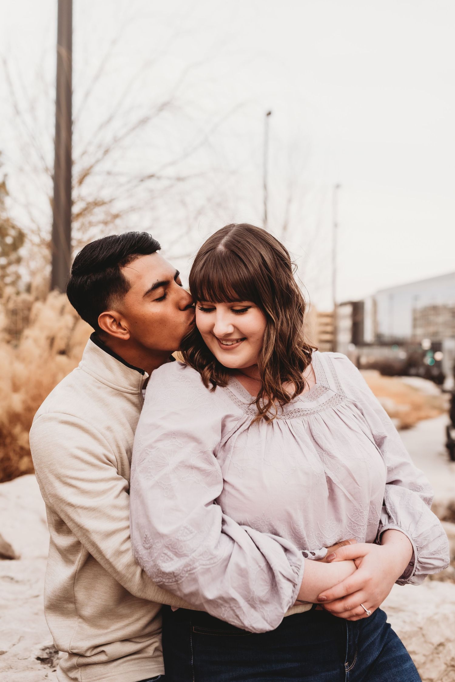 A couple shares an intimate moment outdoors on a winter day.