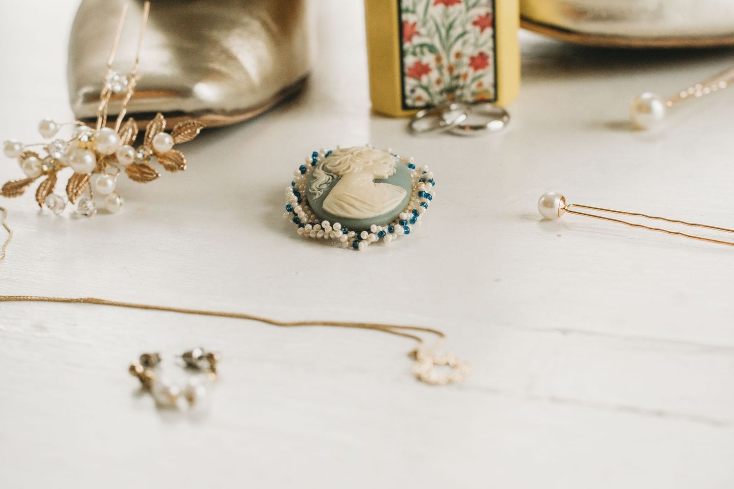 Wedding accessories and jewelry arranged artistically on white surface.