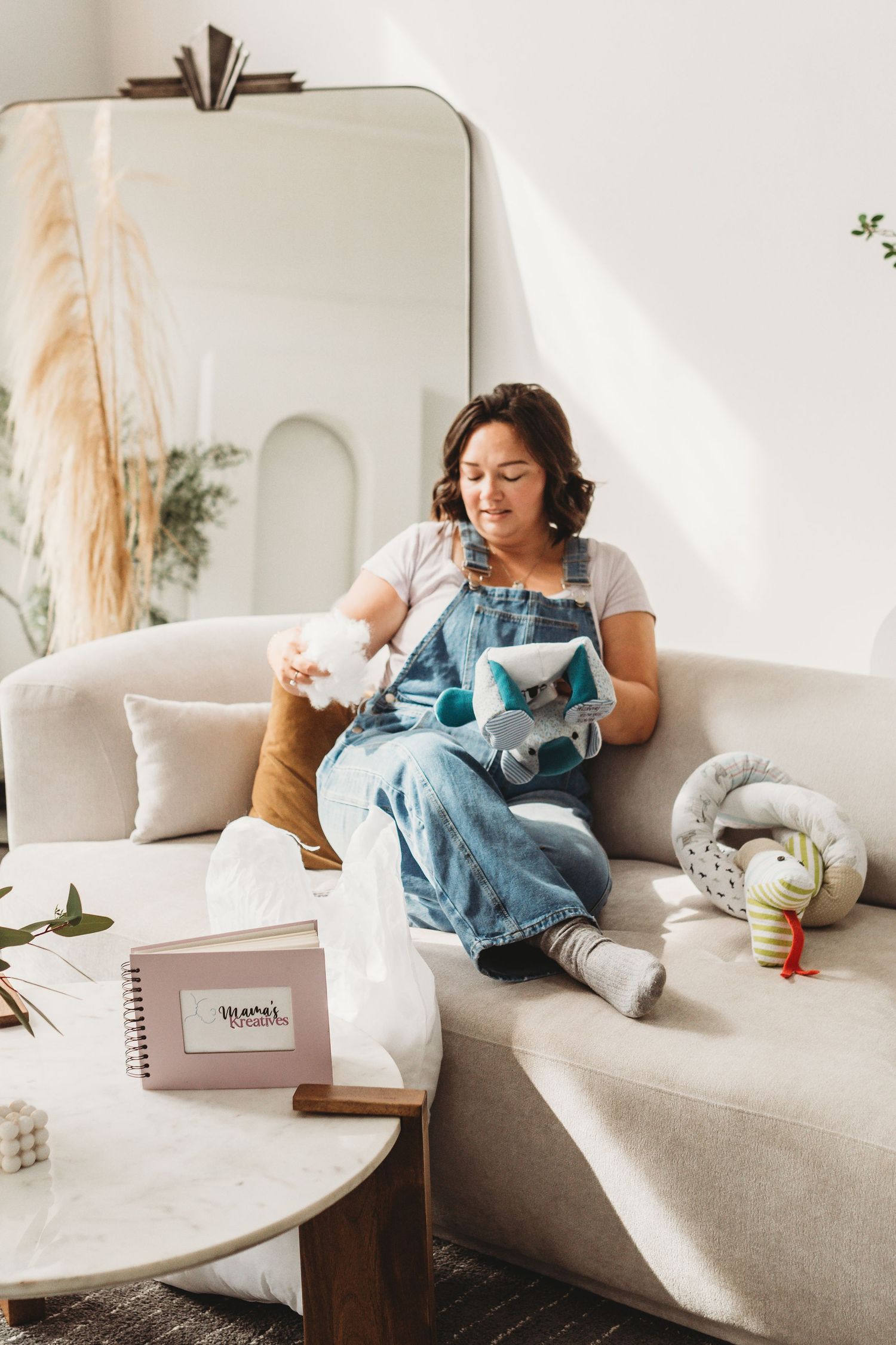 Cozy living room scene with sewing supplies and crafting materials on a beige couch.