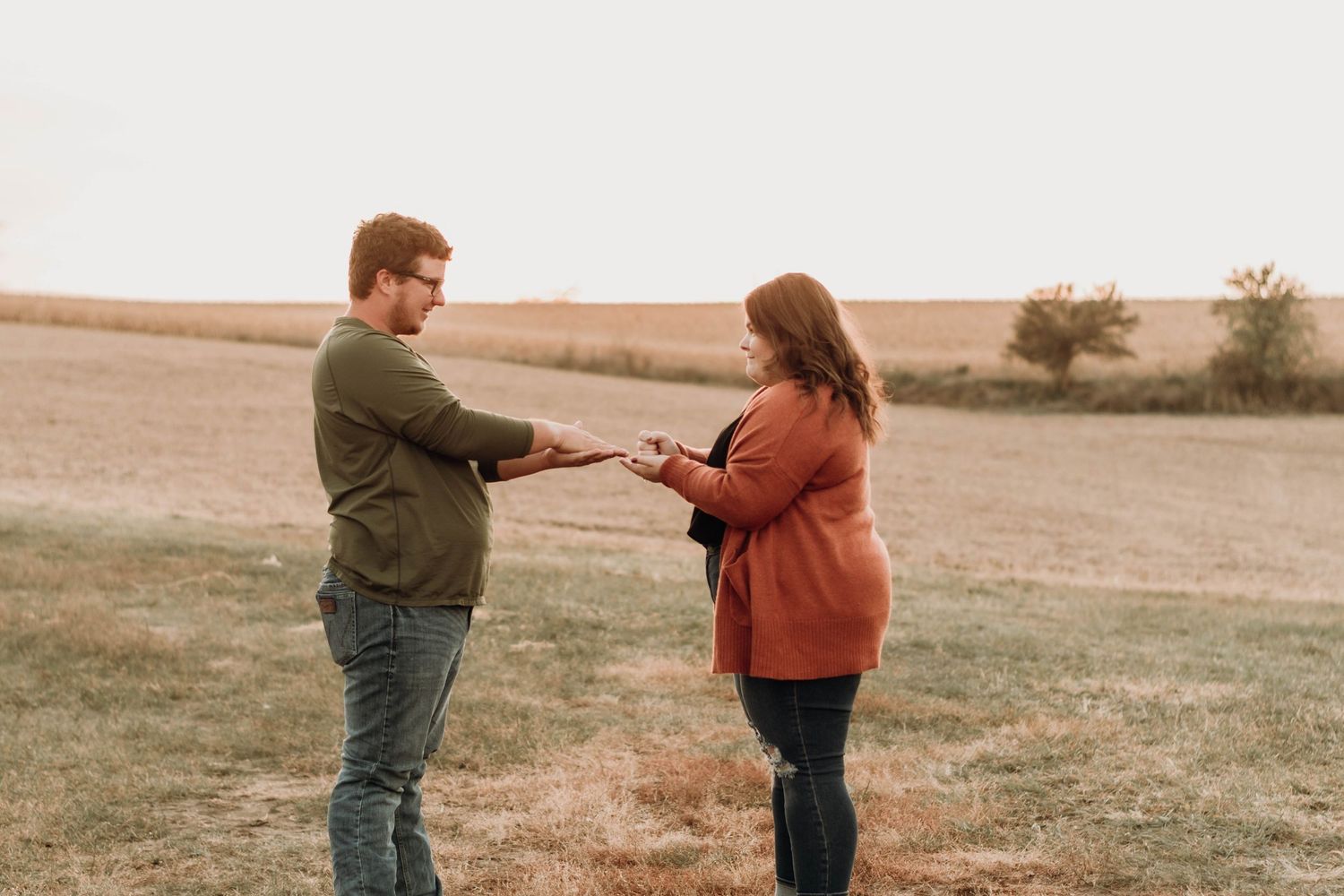 Couple walks together through autumn field during golden hour.