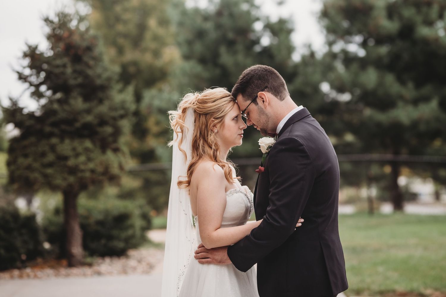 Wedding couple embracing in a romantic outdoor garden setting.