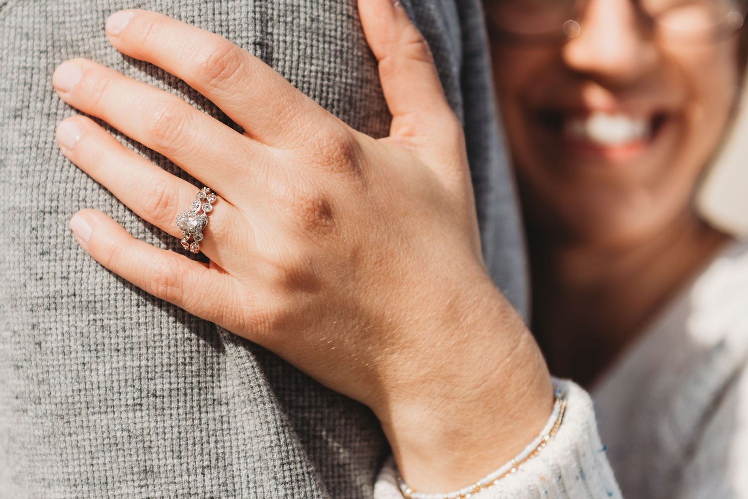 Close-up of hands showing off an engagement ring.