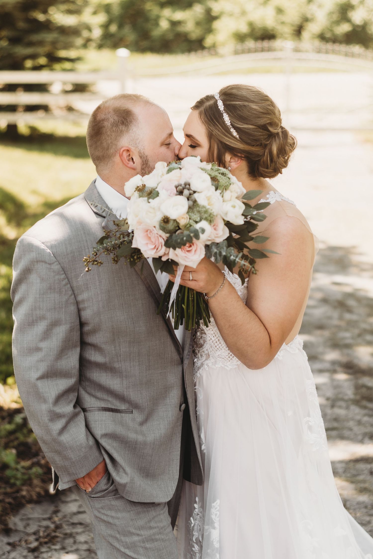 Bride and groom sharing intimate moment with pink and white bouquet.