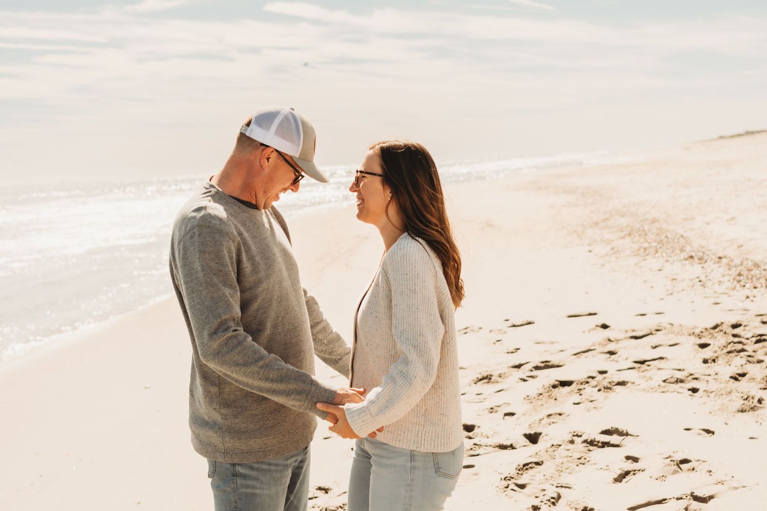 Romantic couple sharing tender moments on a sunny beach.