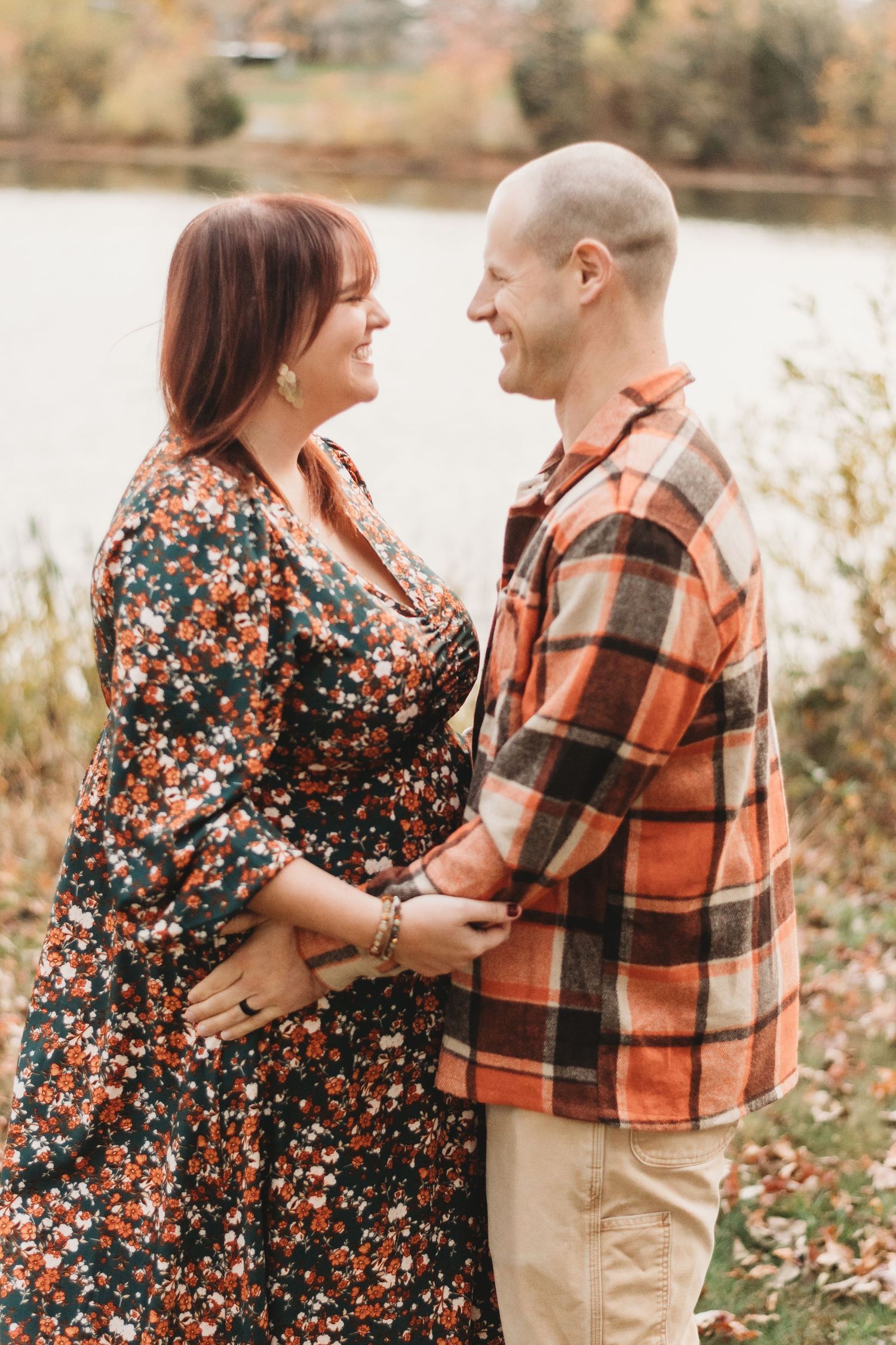 Couple sharing joyful moment outdoors in autumn attire.