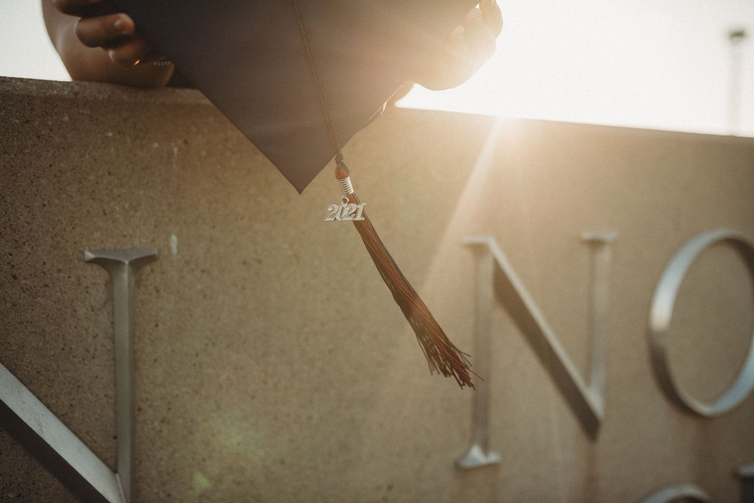Backlit lettering creates dramatic silhouette against bright sunlit background.
