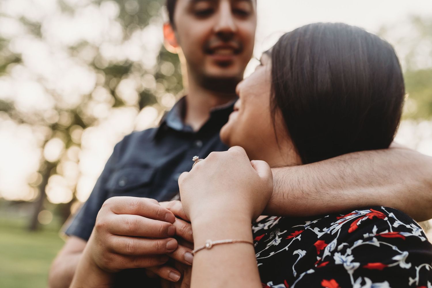 A couple embraces tenderly while sitting together outdoors.